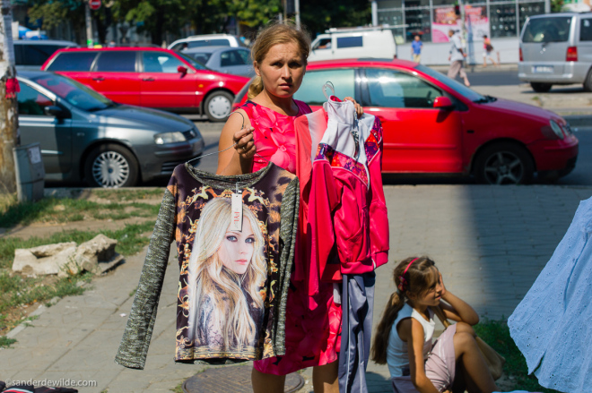 Moldova Chisinau Woman holding shirts to sell in on eo f the main streets of Chisinau