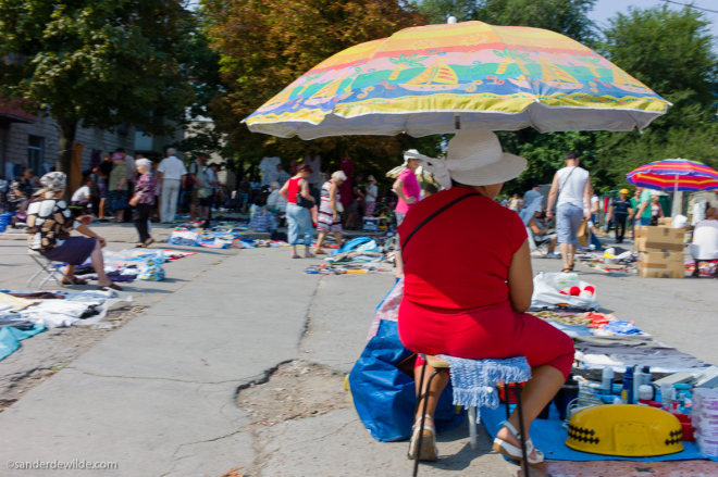 Moldova Chisinau woman in red dress under umbrella at flea market